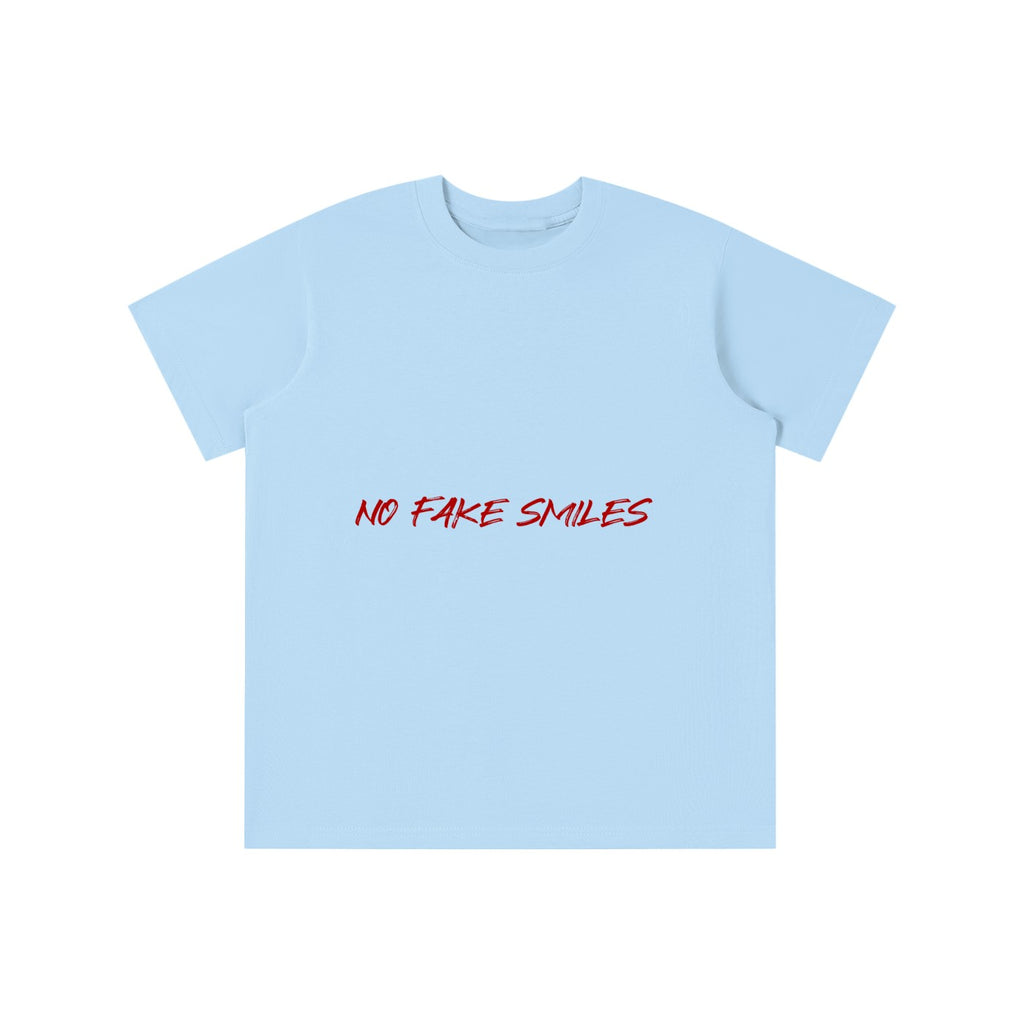 No Fake Smiles light blue cotton kids' t-shirt with a round neck, short sleeves, and red text graphic on the front.