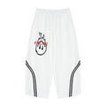 No Fake Smiles white wide leg sweatpants with black piping detail, drawstring waist, and graphic print on the front.