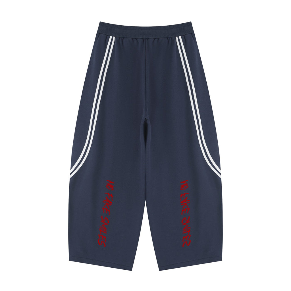 No Fake Smiles wide leg navy sweatpants with white side piping and red graphic text on the back legs.